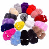 A collection of fluffy angel bunny keychains in various colors including purple, pink, red, and yellow.