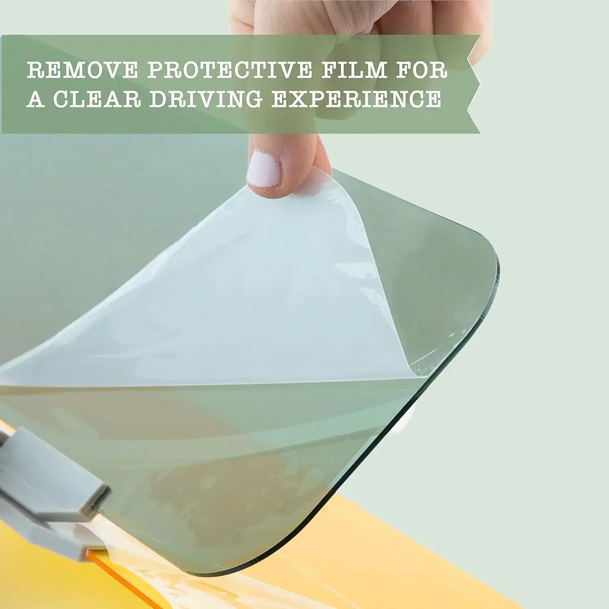 A hand removes a protective film from a car sun visor extender to reveal a clear driving experience.