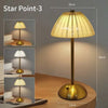 A tall, gold-toned table lamp with a conical shade illuminates a wooden surface.