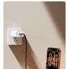 A smartphone is charging via a cable that features a foldable stand, plugged into a wall outlet.