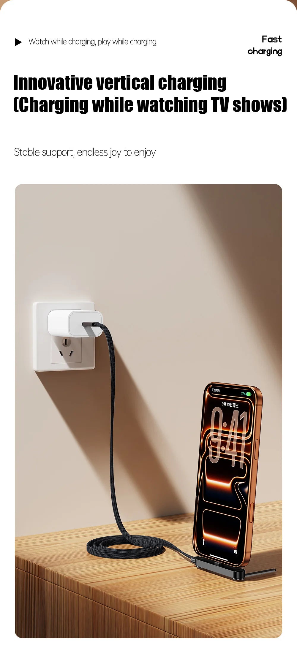 A smartphone is charging via a cable that features a foldable stand, plugged into a wall outlet.