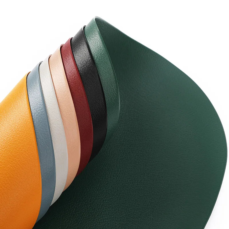 A stack of colorful, reversible non-slip placemats showing various shades of green, brown, orange, and beige.