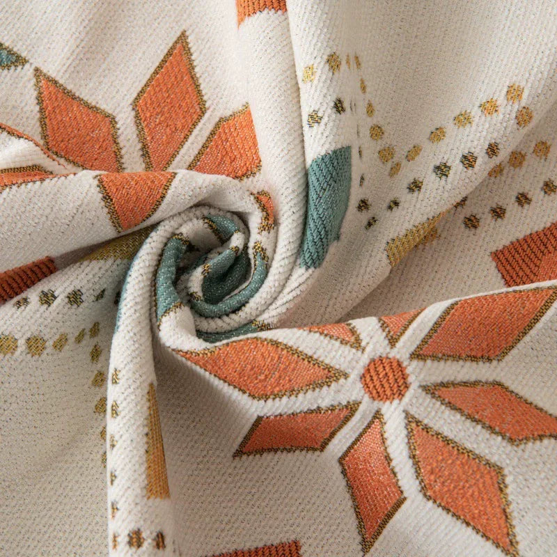 Close-up of a beige and terracotta patterned fabric, likely a sofa cover, showing a rolled texture.