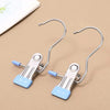 A pair of stainless steel clothespins with hooks used as a space-saving closet organizer