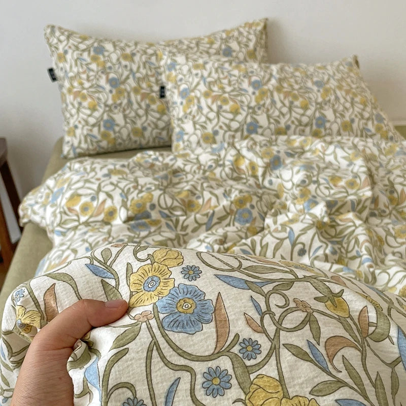 A close-up of a soft printed duvet cover set featuring yellow and blue floral patterns on a light background.