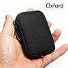 A black compact EDC utility pouch made of premium Dyneema and X-Pac materials is held in a hand.