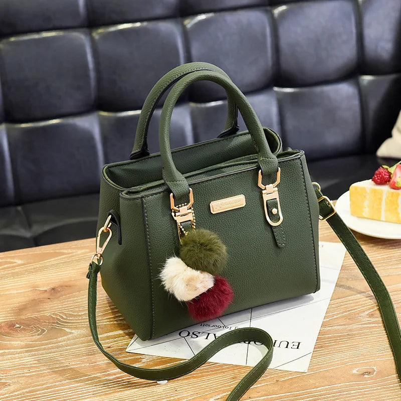 A dark olive green vintage PU leather tassel shoulder bag with a gold-toned strap resting on a wooden surface.