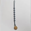 A silicone pacifier clip with a teether, featuring a gray, elongated chain design.