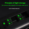 A close-up view of green glow-in-the-dark button stickers inside a car window control panel.
