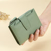 A hand holds a light green genuine leather RFID blocking bi-fold wallet with a zipper closure.