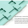 A light mint green folding board with adjustable slots and a reinforced lock fastener for organizing clothing.