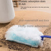 A white electrostatic dusting refill with a fluffy blue fiber head is shown on a wooden surface.