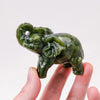 Hand-carved natural jade elephant statue in green being held by a hand