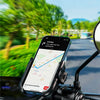 A smartphone is mounted on a motorcycle handlebar using a quick-release mount, displaying navigation directions.
