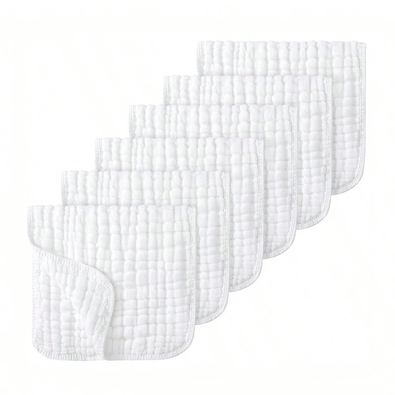 A stack of three white extra soft muslin burp cloths folded and displayed diagonally.