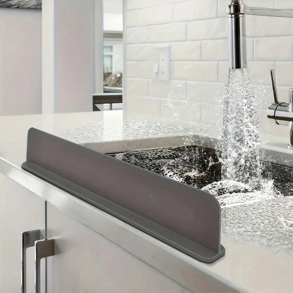 A silicone sink splash guard with a suction cup is installed over a kitchen sink, directing water flow.