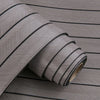Roll of gray 3D grille pattern peel-and-stick wallpaper shown in a close-up view.