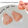 A pink squishy pimple popper fidget toy is shown being pinched and squeezed on a white plate.
