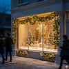 A display of gold and white Christmas garlands and trees in a storefront window decorated with twinkling lights.