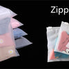 A collection of clear self-adhesive resealable storage bags in various pastel colors and shades.