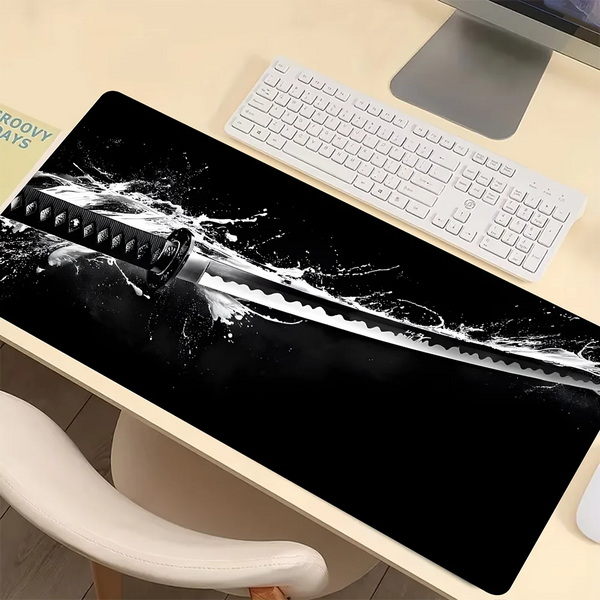Schwarze Gaming-Mousepad mit dramatischem weißem Schwertdesign auf schwarzem Hintergrund und weißer Tastatur daneben.