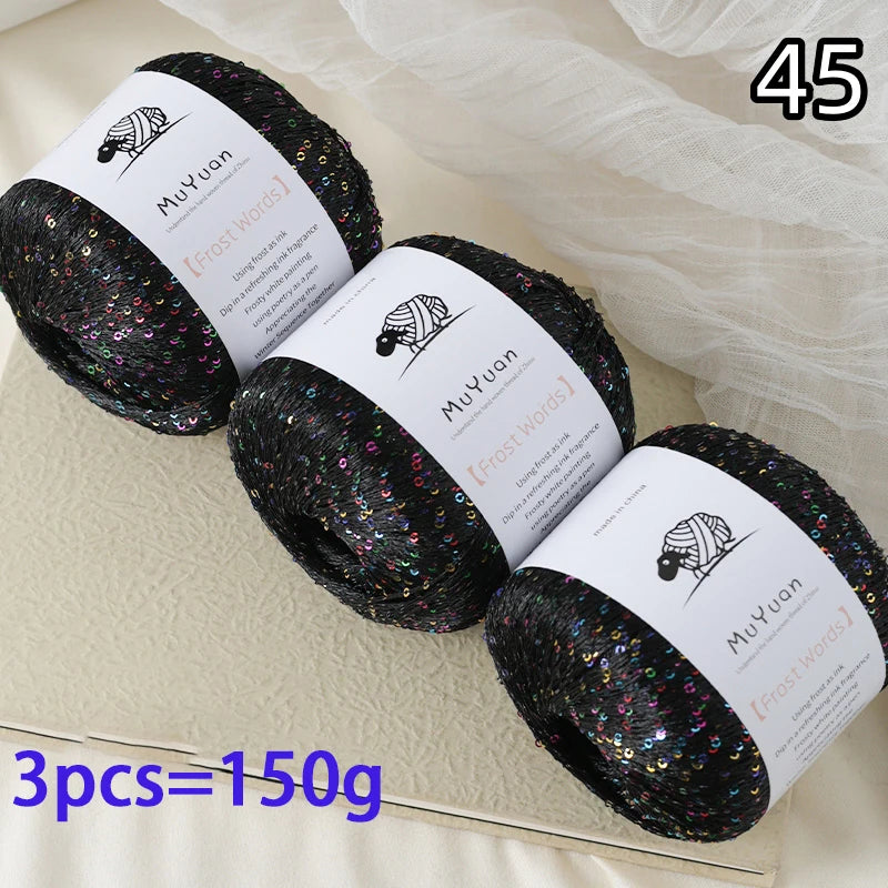 Three spools of black glitter yarn labeled Frost Words for knitting and crafting