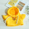 A bright yellow hoodie with a stitched bear face detail, displayed next to product information.