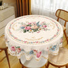 Vintage floral tablecloth with pink and blue roses decorating a round dining table set.