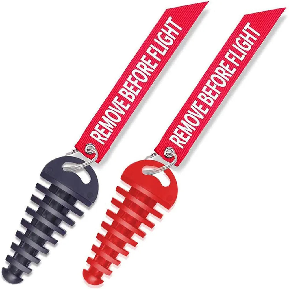 A red rubber exhaust wash plug with a black threaded tip and a tag that reads REMOVE BEFORE FLIGHT