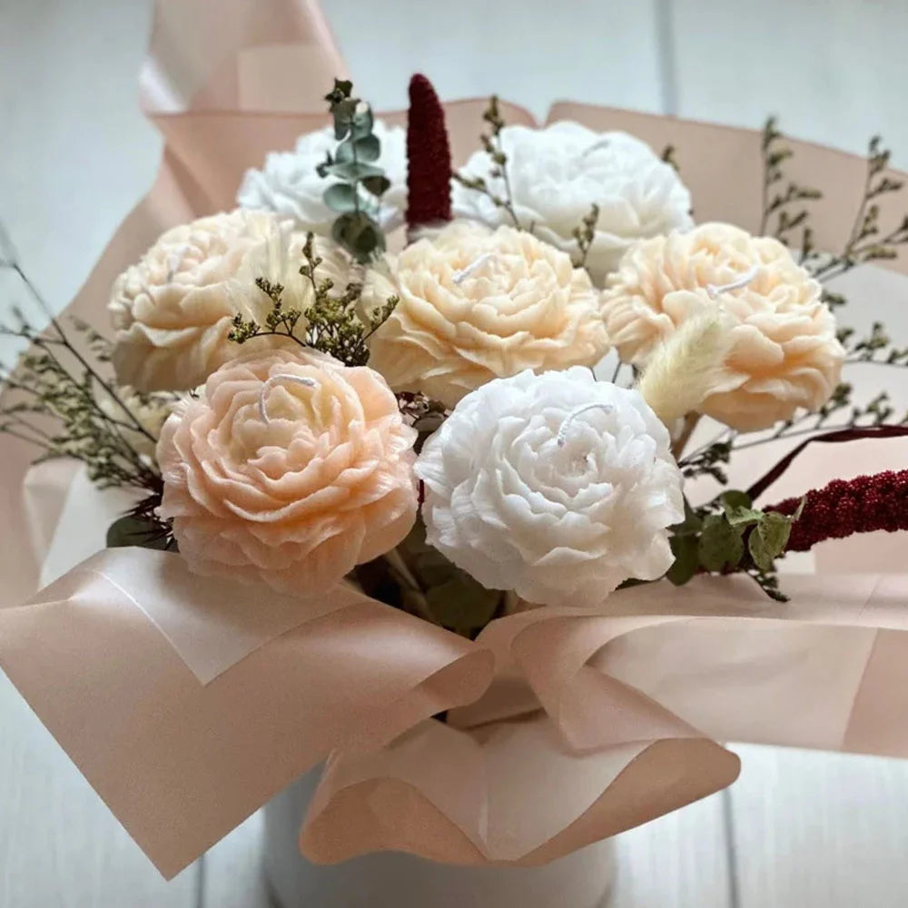 A bouquet of soft peach and white peony-like flowers arranged in pink tissue paper.