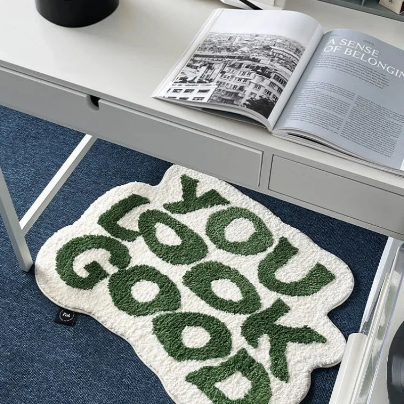 A soft, non-slip letter rug featuring a green and white pattern on a blue rug.