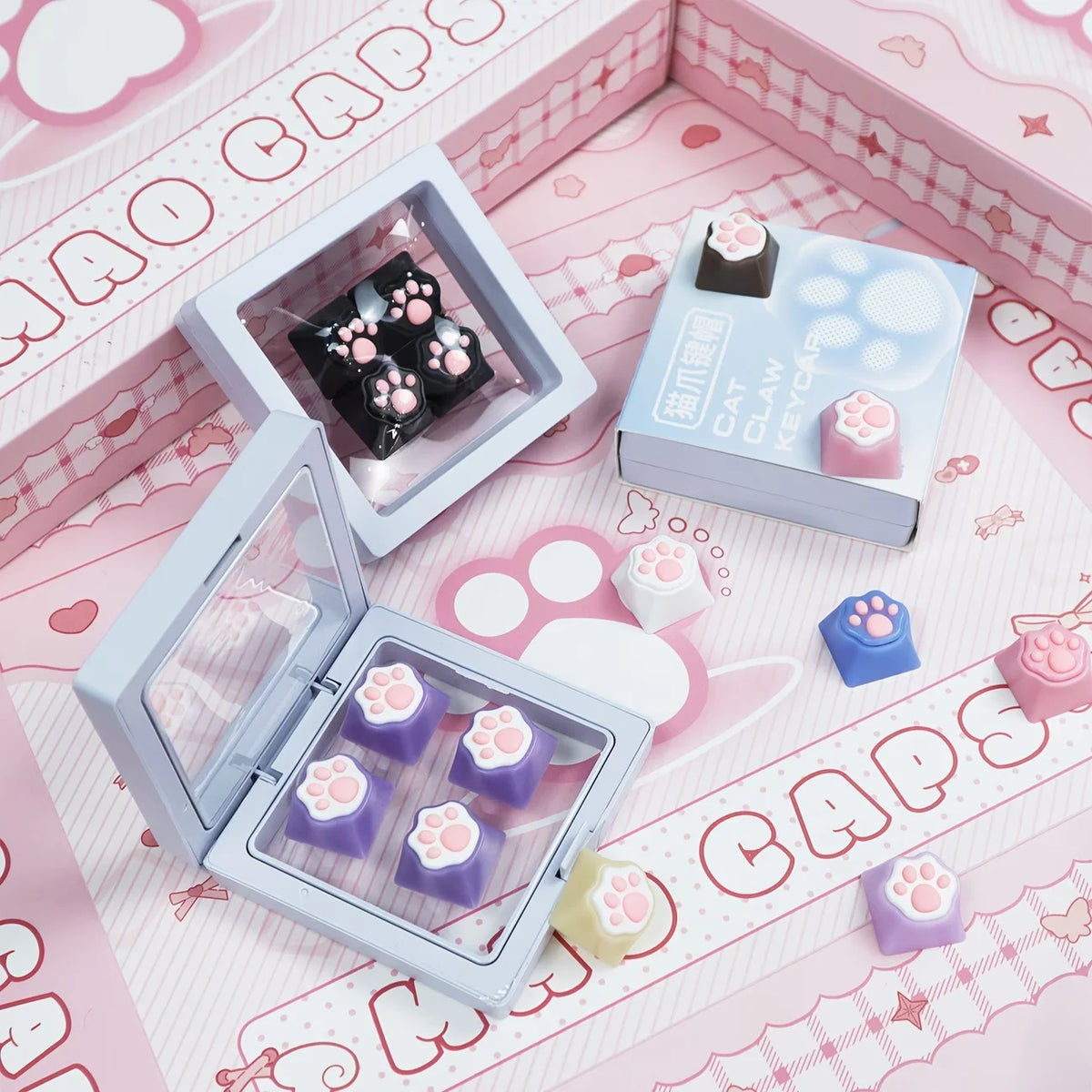 A collection of pink and purple silicone cat paw and heart keycaps for MX switches displayed on a pink background.