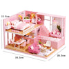 Pink wooden dollhouse miniature building kit with furniture featuring a bedroom, dining area, and living space.