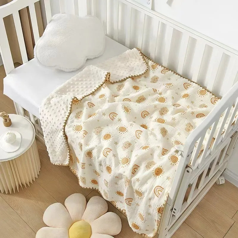 A white baby swaddle blanket with an adorable bear print and sun motifs is displayed on a wooden crib.
