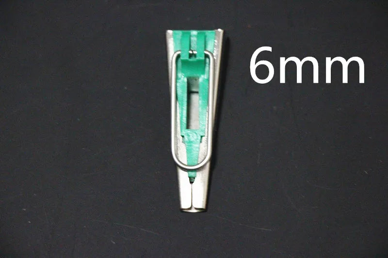 A close-up view of a stainless steel bias tape maker, measuring 6mm, against a dark background.
