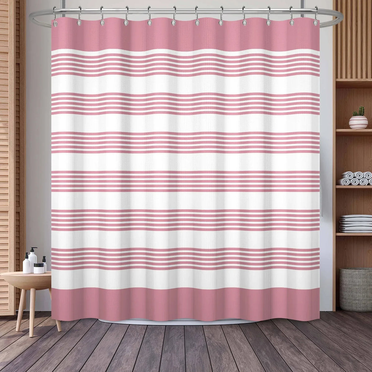A pink and white striped waffle weave shower curtain hanging on a rod.