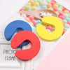 Colorful foam door stoppers in blue, red, and yellow with star accents displayed on a white card.