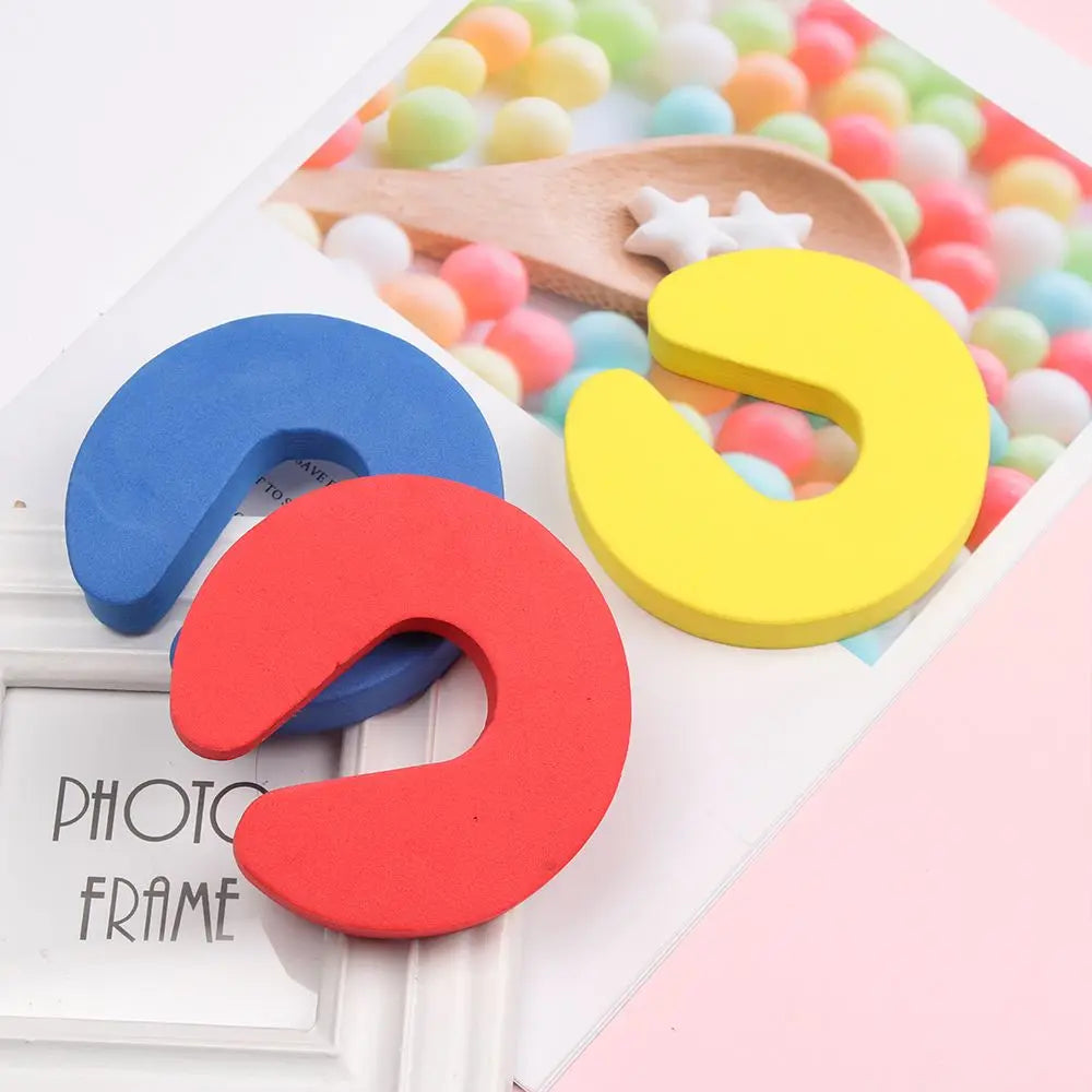 Colorful foam door stoppers in blue, red, and yellow with star accents displayed on a white card.