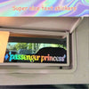 A close-up of a car mirror showing a text sticker that reads passenger princess