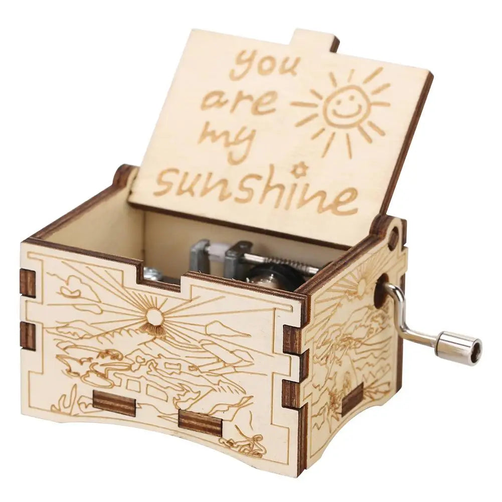 A hand-cranked wooden music box featuring a cutout with the text You Are My Sunshine.