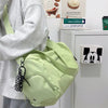 A light green canvas travel tote bag with a black patterned crossbody strap is shown next to a white Mickey Mouse framed pict
