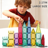 A child is building a tower with colorful magnetic tiles, showing various sizes and colors like pink, blue, yellow, and green