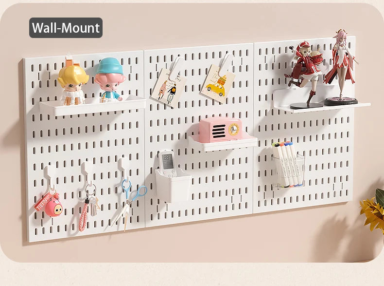 A white wall-mount pegboard organizer featuring shelves and hooks for storing various small items like dolls, tools, and acce
