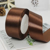 A roll of luxurious brown satin ribbon used for gift wrapping or DIY crafts.