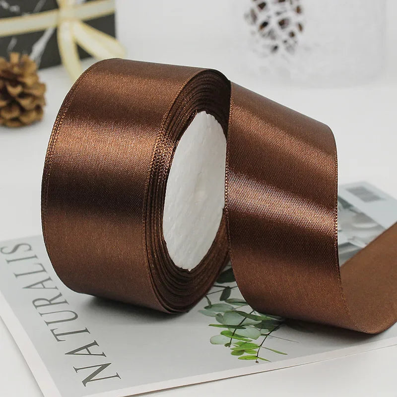 A roll of luxurious brown satin ribbon used for gift wrapping or DIY crafts.