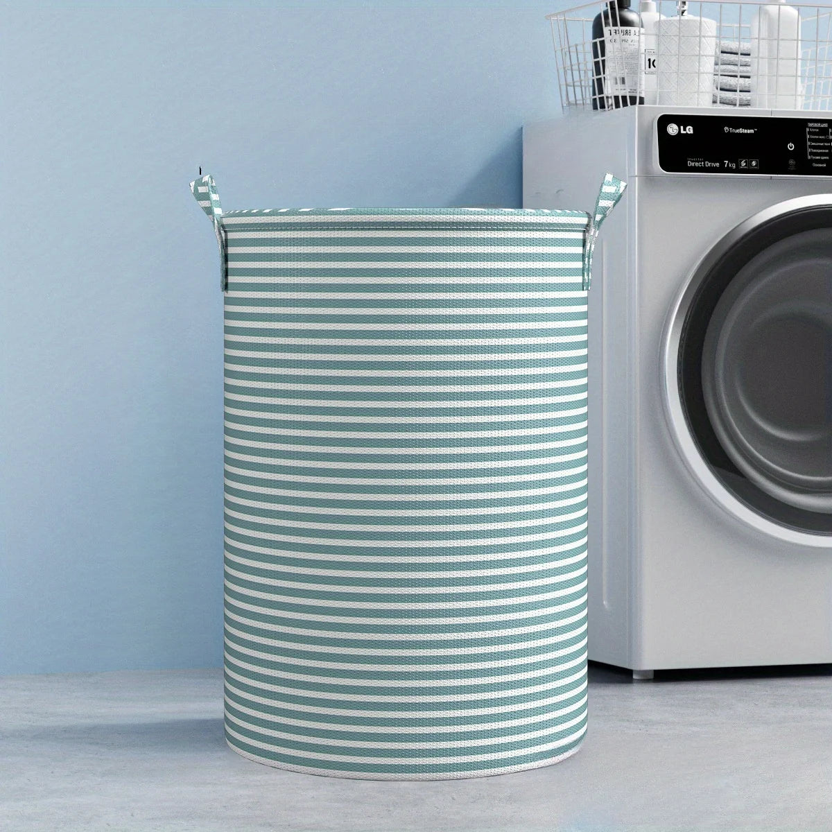 A cylindrical striped laundry basket with handles sits in front of a white LG washing machine.
