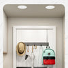 A set of six no-drill aluminum wall hooks with adhesive backing are installed on a white door for hanging clothes.