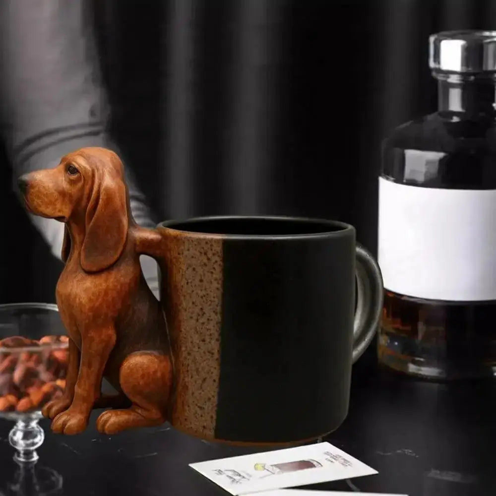 A brown dachshund figurine with a puppy handle rests next to a black coffee mug and a glass bottle.