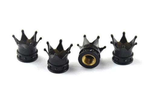 A set of four black universal crown valve caps for automotive or mechanical use.
