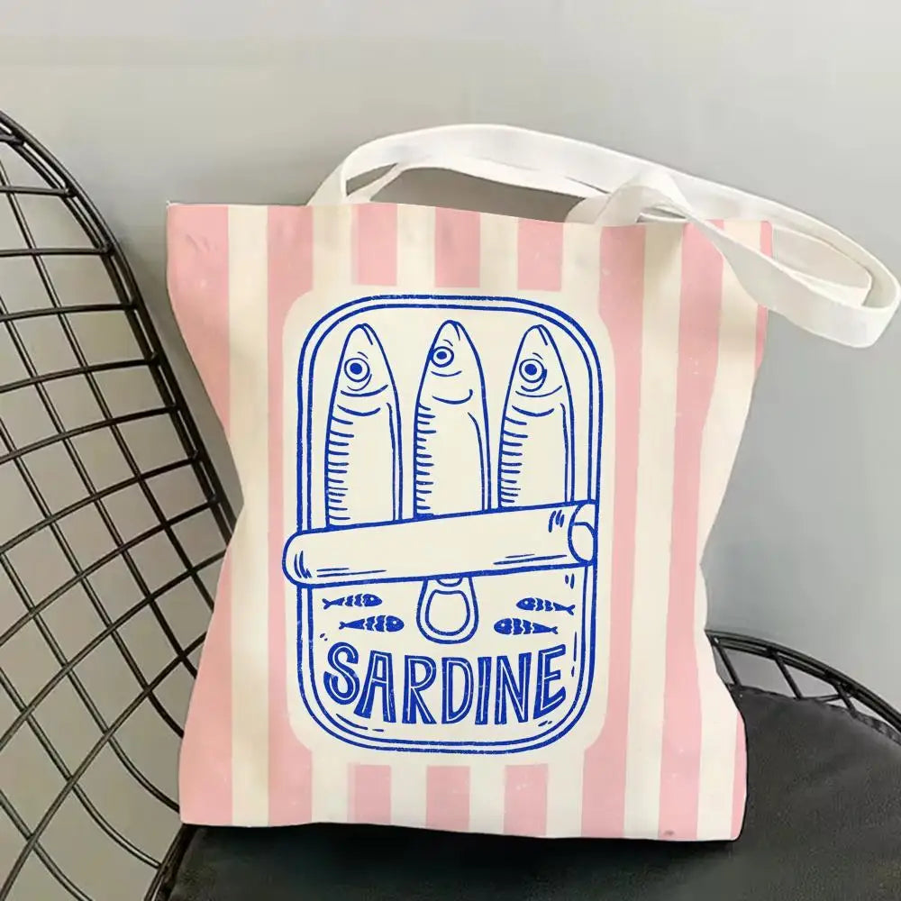 A pink and white striped canvas tote bag featuring a blue line drawing of a sardine.